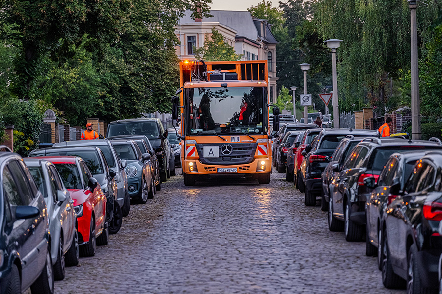 Müllfahrzeug fährt durch eine Straße.