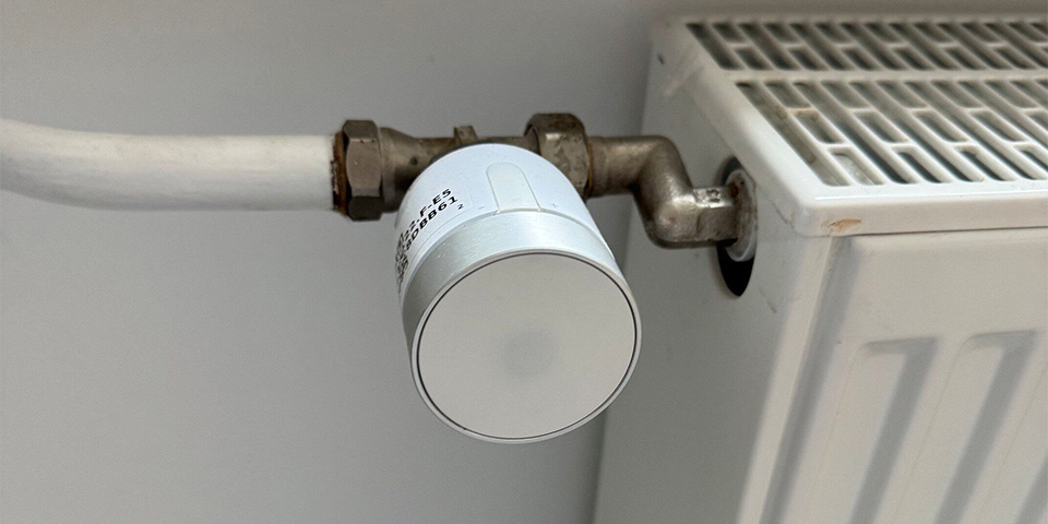 Nahaufnahme eines weißen Thermostatventils an einem Heizkörper.