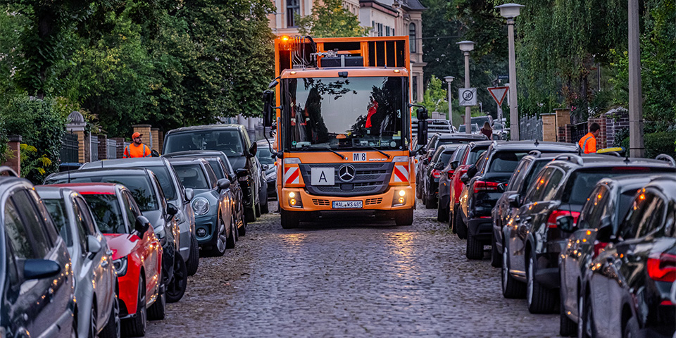Müllfahrzeug fährt durch eine Straße.